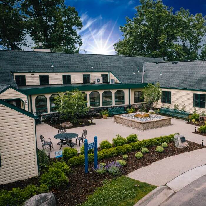 A tranquil courtyard nestled between residential structures at Rose Hill Center, offering a serene space for residents to relax and unwind