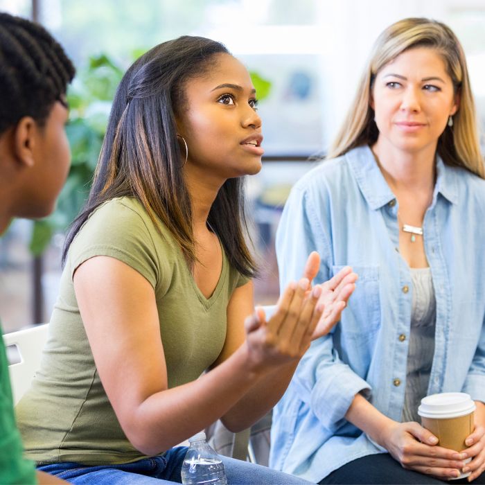 A photo capturing a supportive group therapy session, where individuals with mental health challenges engage in open discussions and receive guidance from mental health professionals