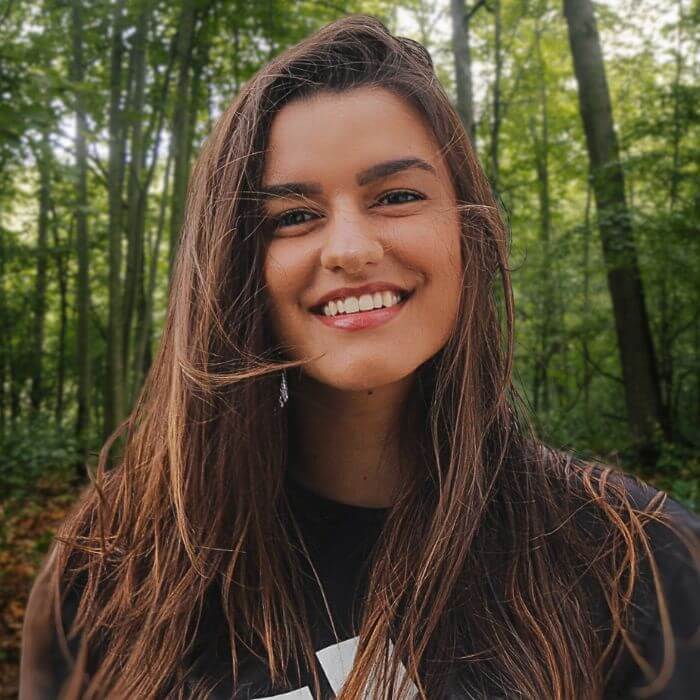 A young woman in front of Rose Hill Center's natural landscape