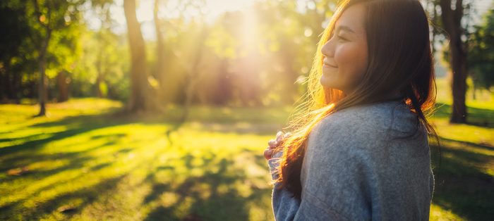 healthy woman in woods with sunrise photo